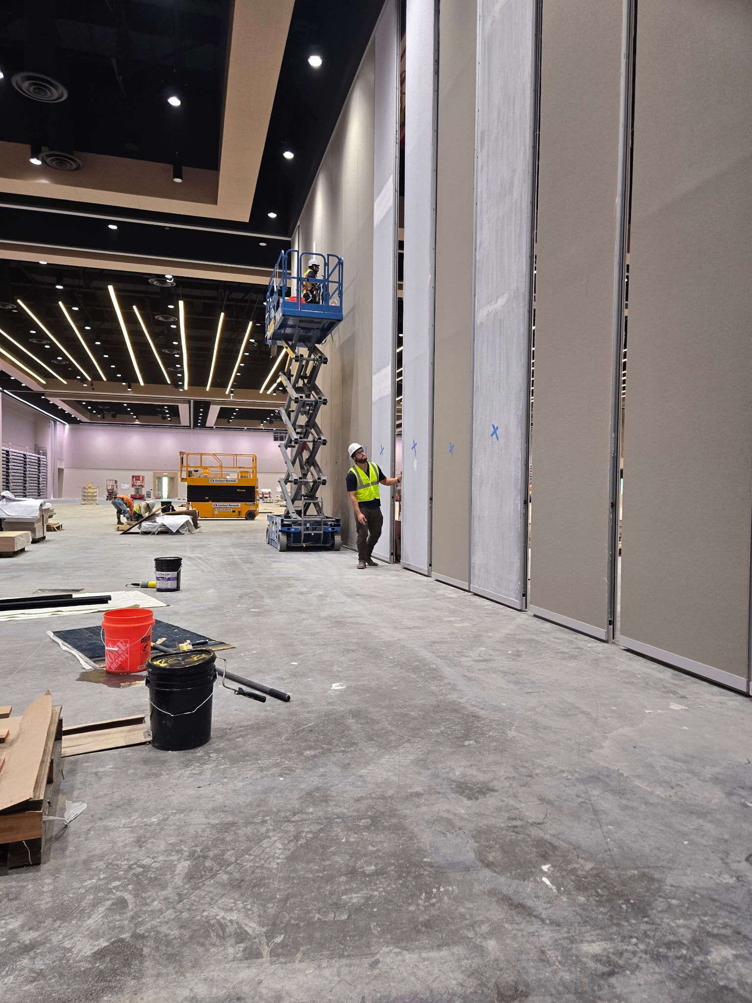 MotionSpan technicians preparing and recovering 30-foot Moderco operable partition panels at a convention center.